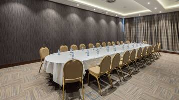 A conference room with a long table, chairs, and water bottles.
