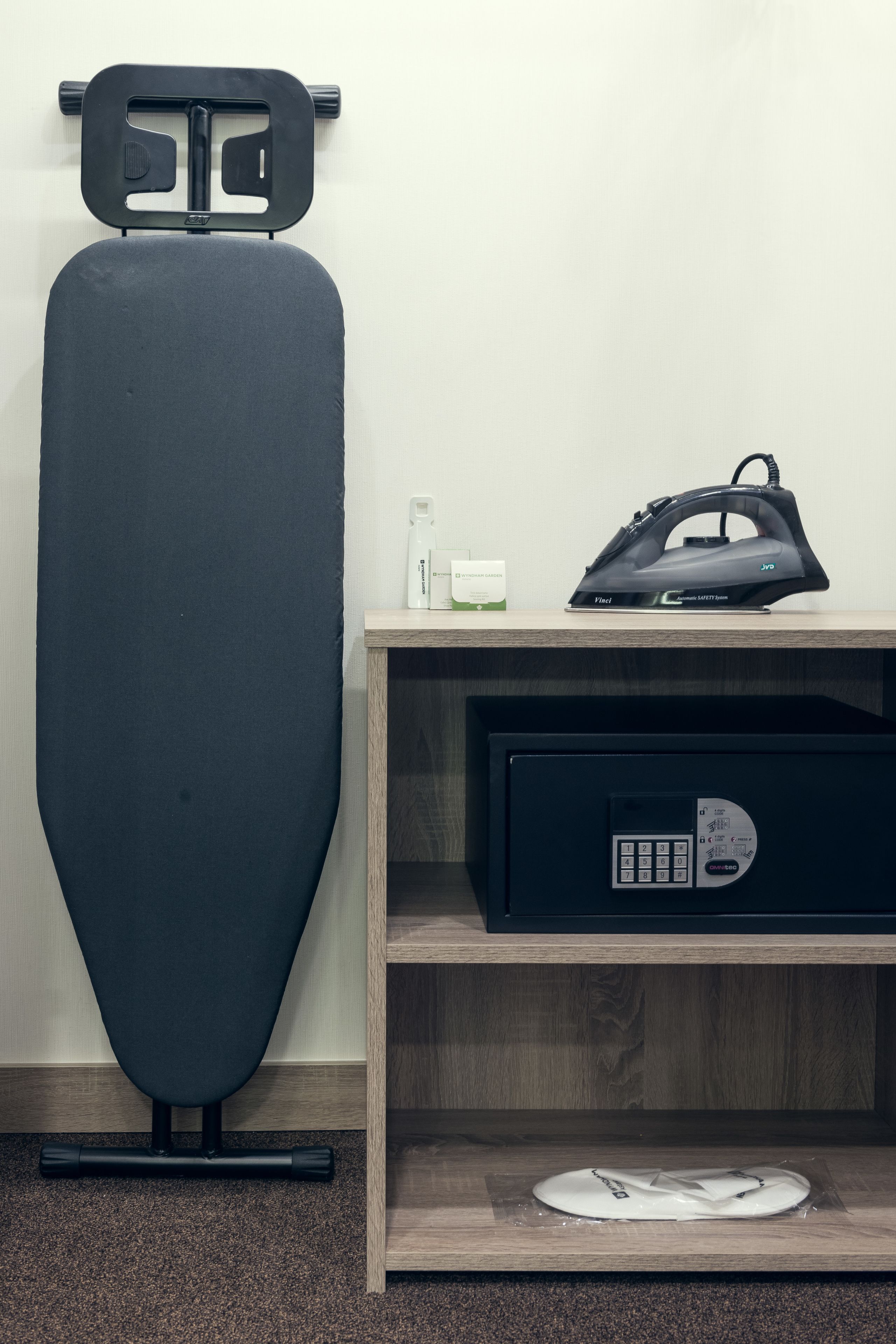 Una habitación con una mesa de masaje, un armario de madera con un panel de control y una bolsa negra encima.