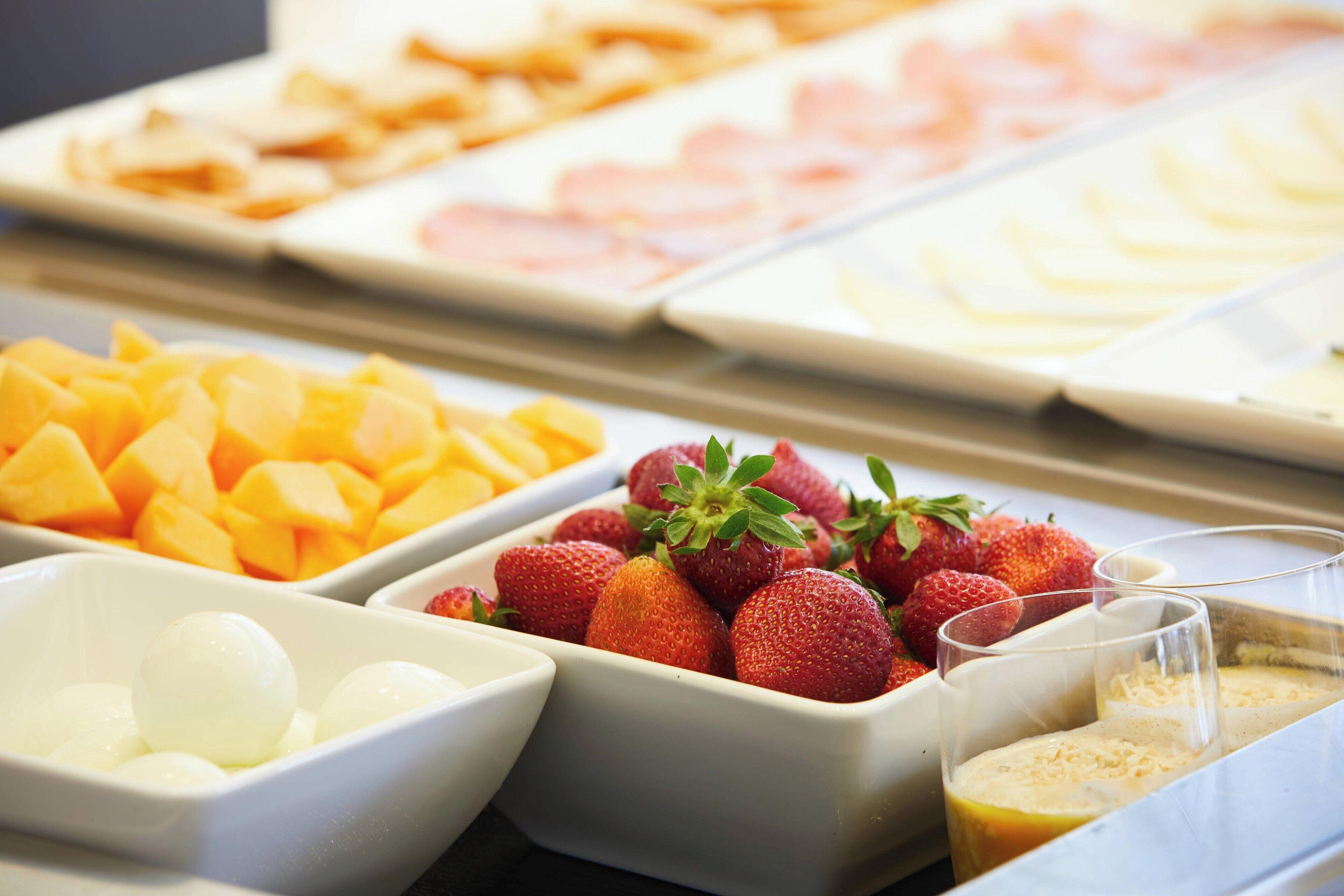 A buffet with various fruits and beverages.