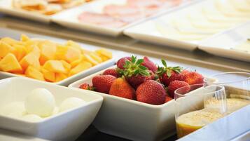 A buffet with various fruits and beverages.