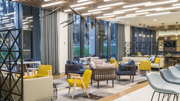 A modern lounge area with seating arrangements, large windows, and contemporary lighting fixtures. - Courtyard by Marriott Edinburgh West (Edinburgh)