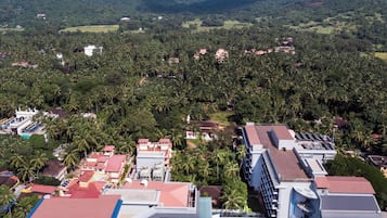 Un complejo turístico con varias edificaciones, piscina y un paisaje exuberante.