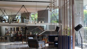 Eine moderne Hotelhalle mit einer Sitzecke, einer Treppe und einer Bar.