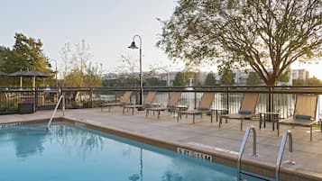 A swimming pool with lounge chairs and a view of a body of water.