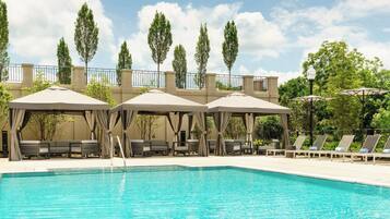 Una piscina al aire libre, camas de piscina gratis, sombrillas