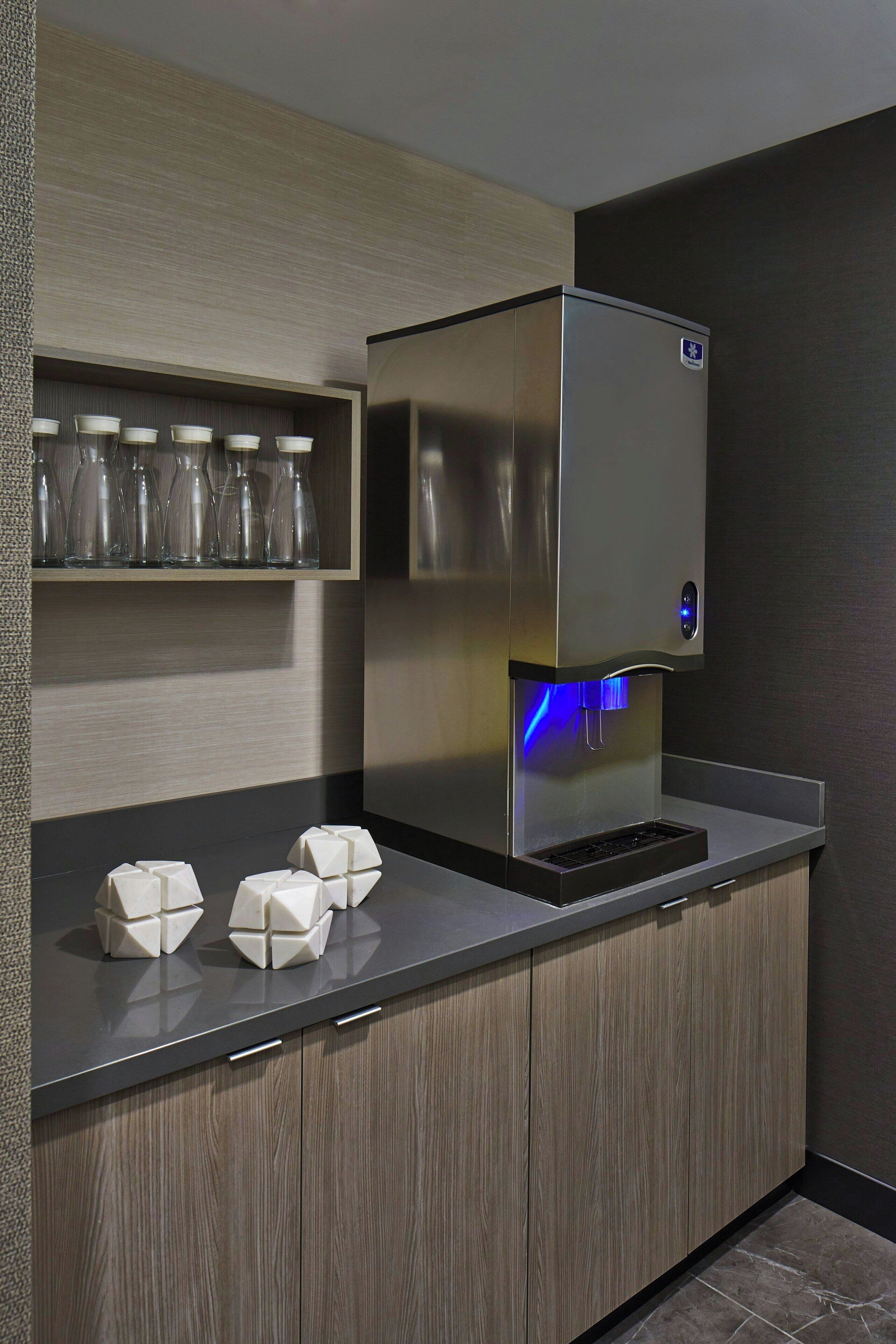 A modern kitchen with a stainless steel refrigerator, a built-in wine cooler, and a sleek countertop.