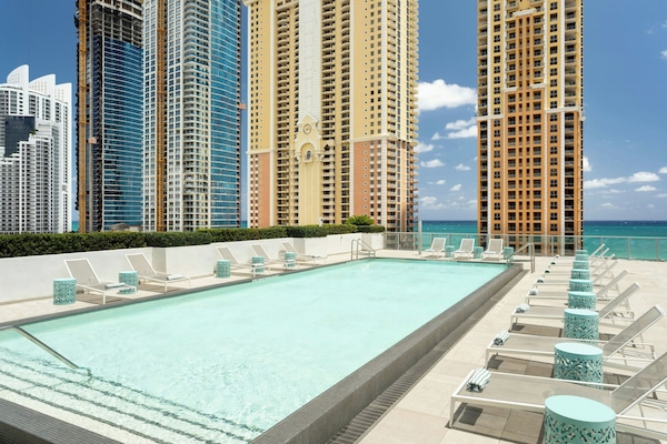 Una piscina al aire libre, sillones reclinables de piscina