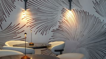 Un interior moderno con una pared estampada, una mesa redonda y dos sillas.