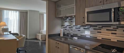 A modern kitchen with stainless steel appliances, a tiled backsplash, and wooden cabinets.