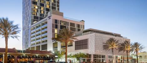 A modern hotel with multiple floors, a well-maintained garden, and a variety of dining options.
