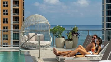 Una piscina al aire libre, sillones reclinables de piscina