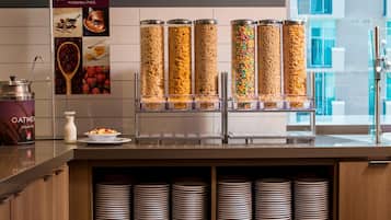 A breakfast bar with cereal dispensers and a sign promoting customization.