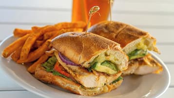 Ein Sandwich mit Zahnstocher, dazu Pommes auf einem Teller.