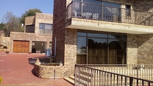 A modern two-story building with a brick facade, large windows, and a balcony.
