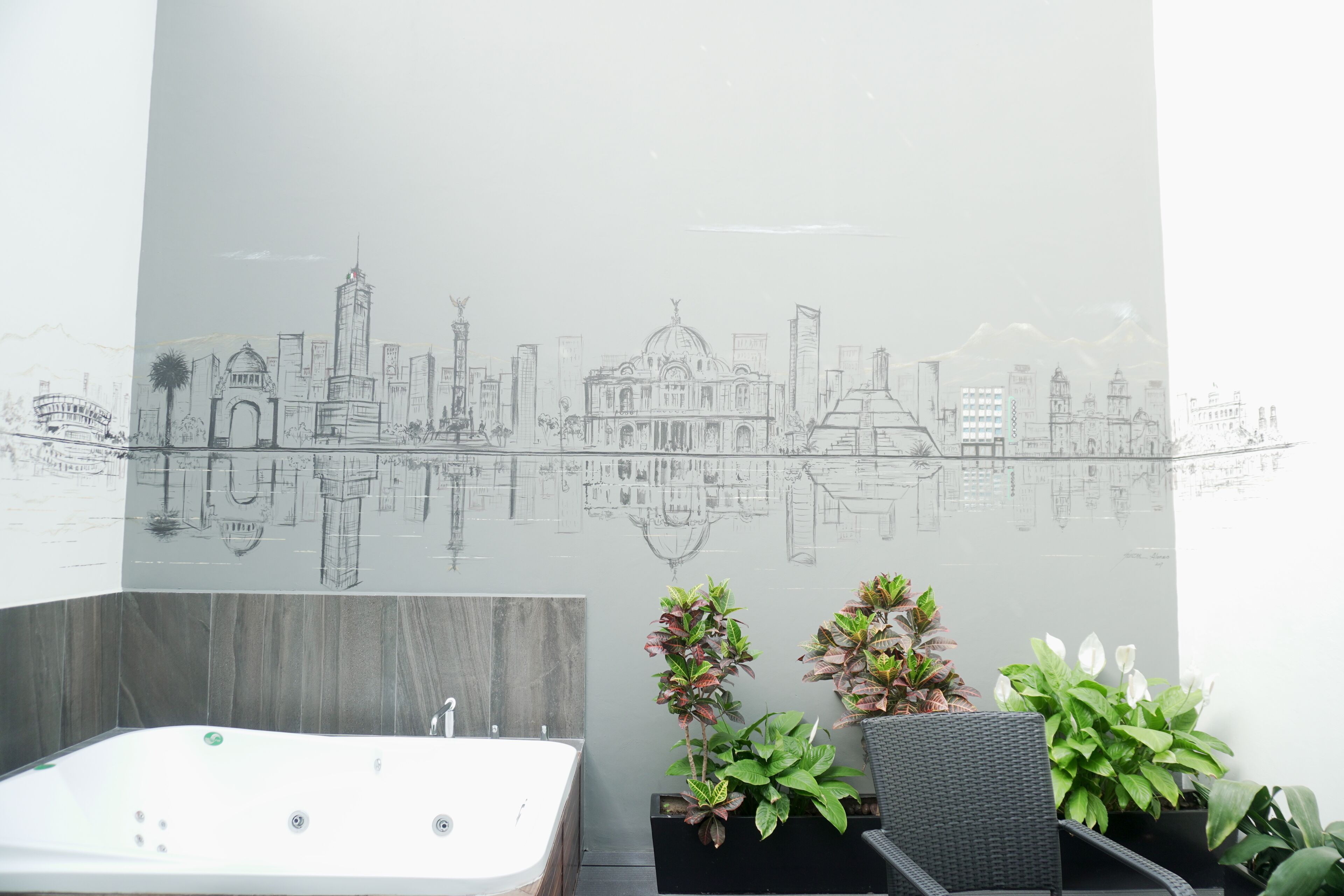 Un baño con un espejo grande, una bañera y plantas en macetas.