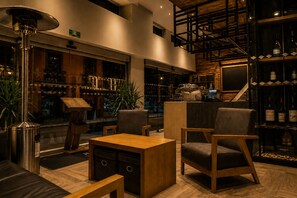 Um interior moderno com assentos, um bar e uma escadaria.