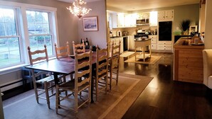A spacious kitchen with wooden chairs, a dining table, and a chandelier. - Quiet location. Home is 1/2 a mile to Seawall Beach and 3 miles to town center. (Southwest Harbor)