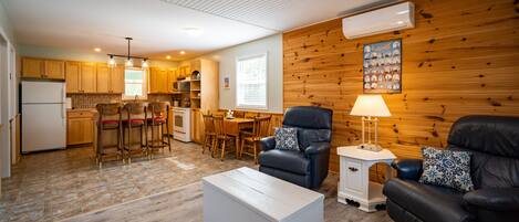 Un espacio habitable compacto con cocina, comedor y zona de estar.