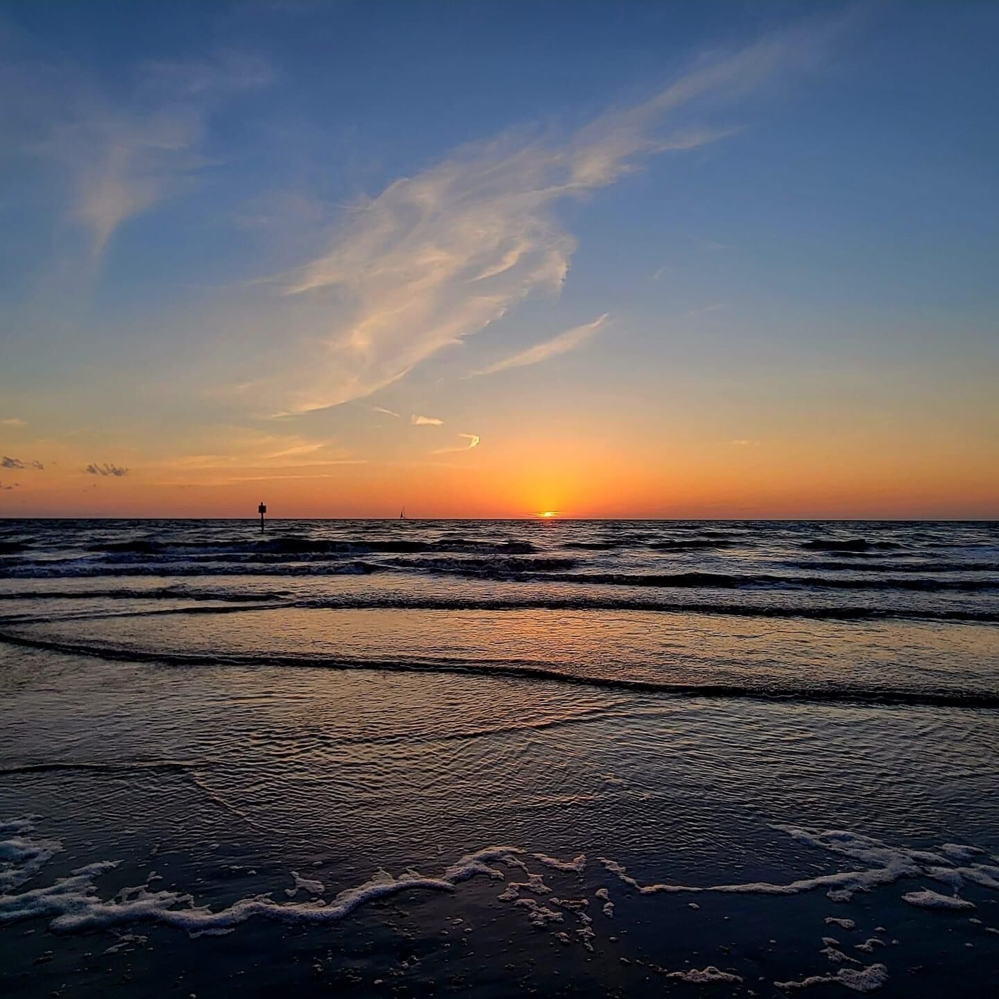 A beach scene with waves and a sunset.