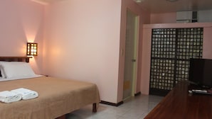 A hotel room with a bed, a TV, a desk, and a wardrobe. - Blue Coral Resort Boracay (Boracay Island)