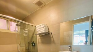 A modern bathroom with a glass shower enclosure, a toilet, a sink, and a mirror. - Vicky House (Hualien City)