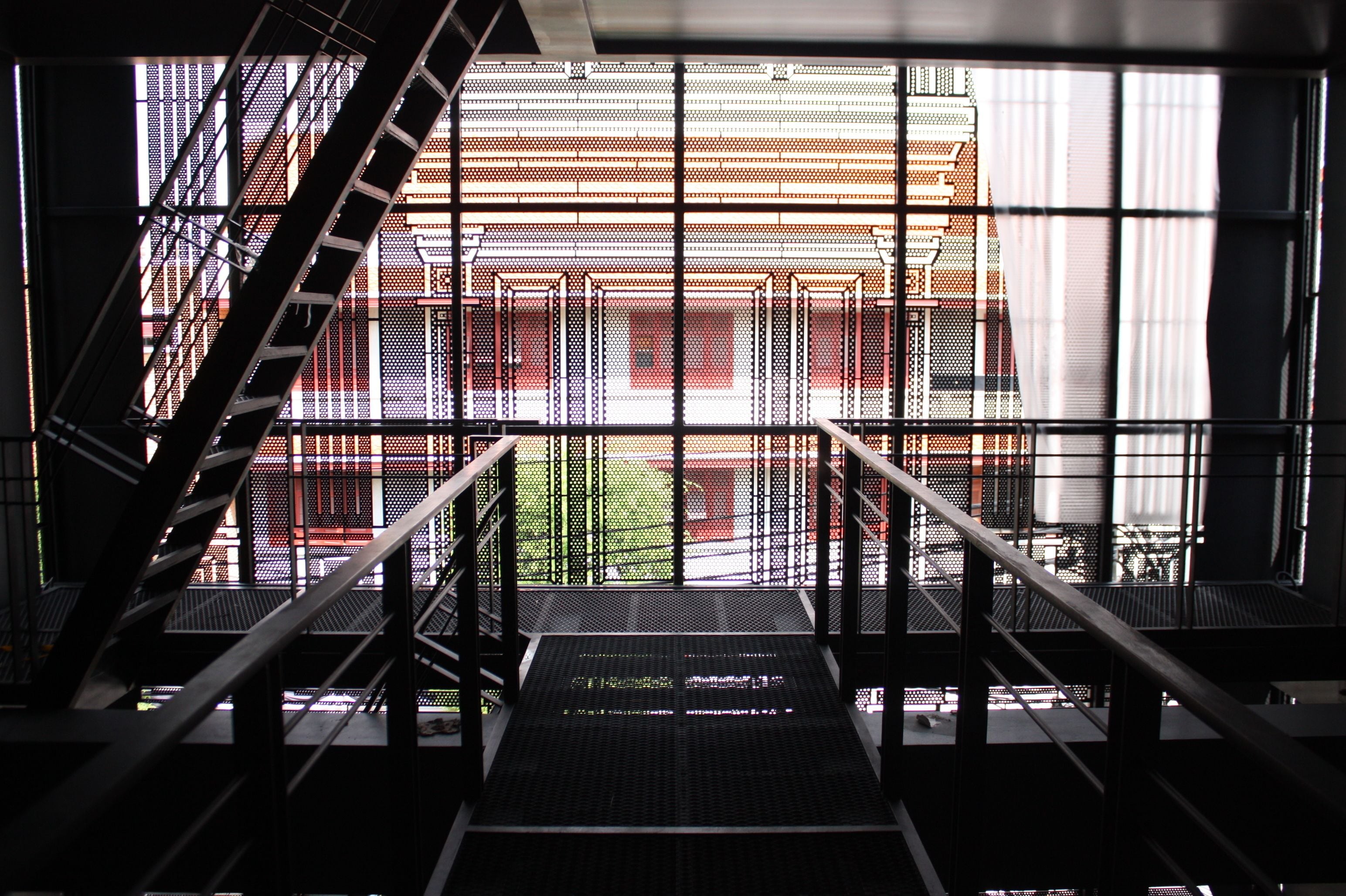 A modern building with a metal staircase leading to a lower level.