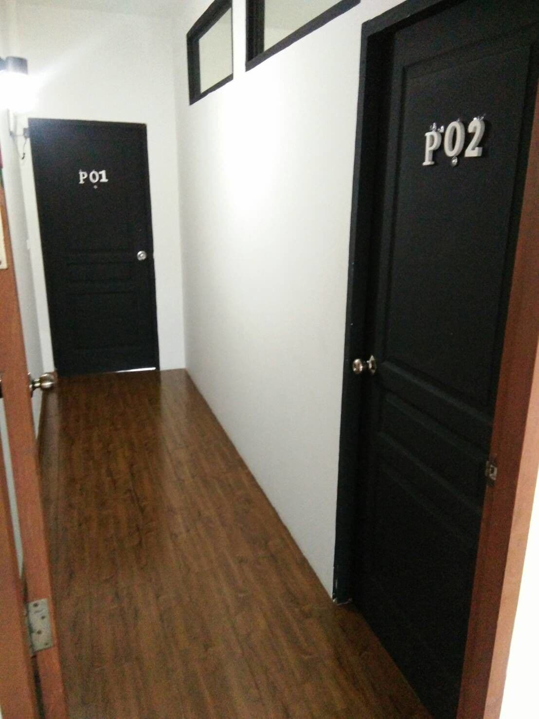 A hallway with two black doors labeled "P01" and "P02".