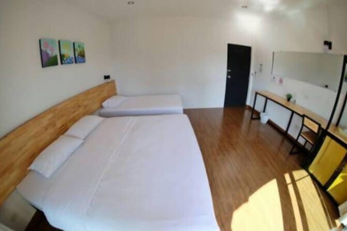 A room with a large bed, a wooden headboard, a bench, and a mirror on the wall.