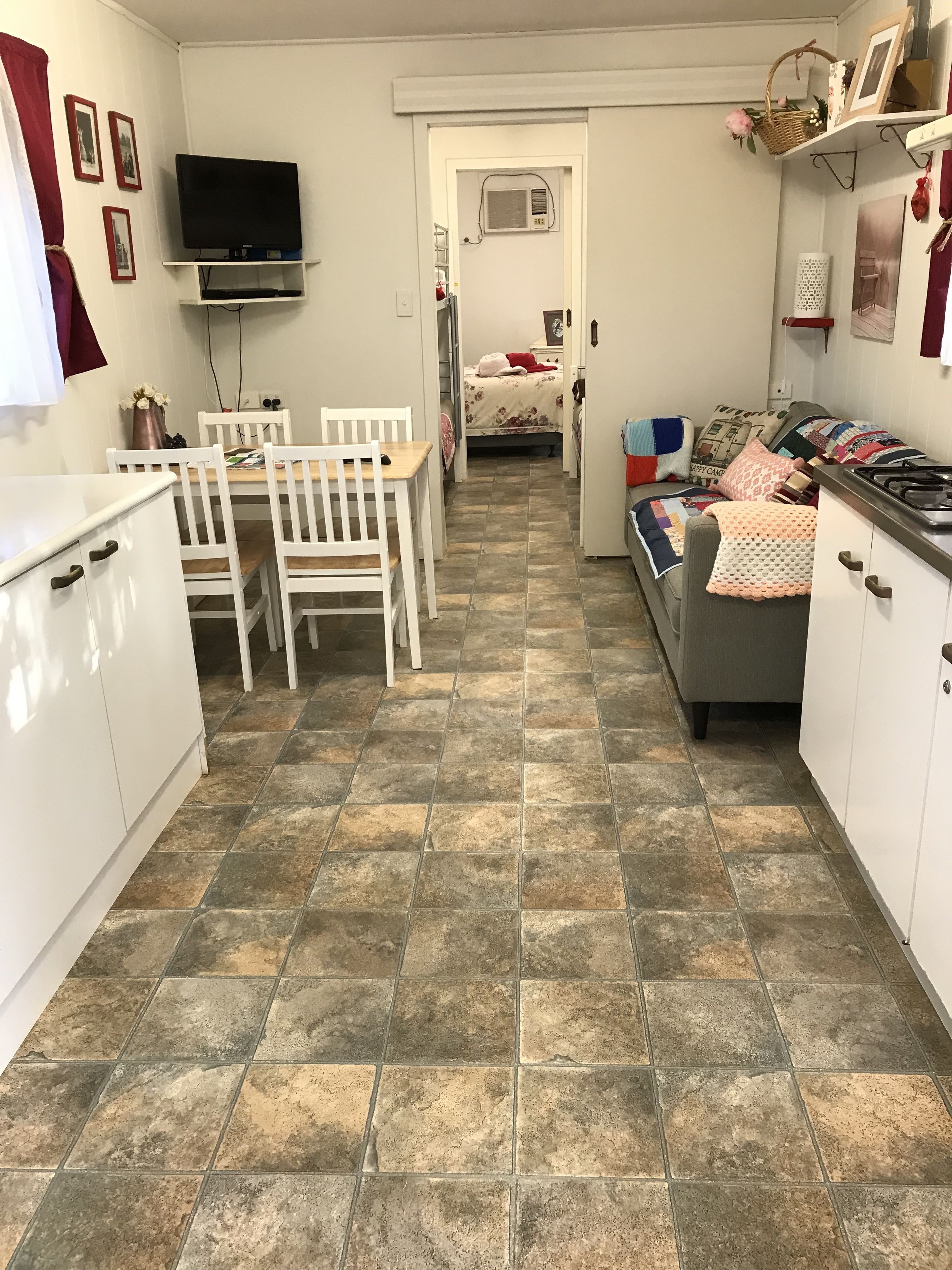 Un espacio habitable compacto con kitchenette, comedor y dormitorio.