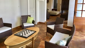Un soggiorno con mobili in vimini, un tavolino in legno e una scacchiera.