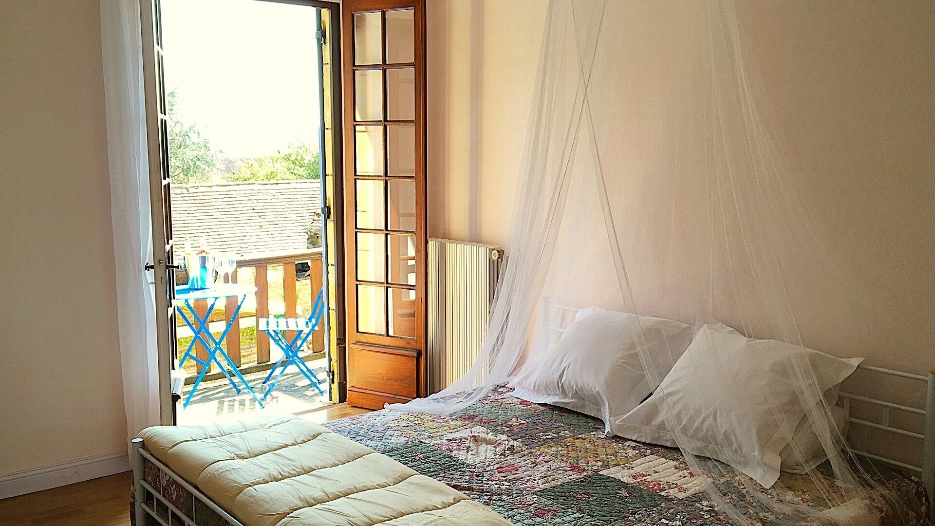 A bedroom with a bed, a window, and a view of the outside.
