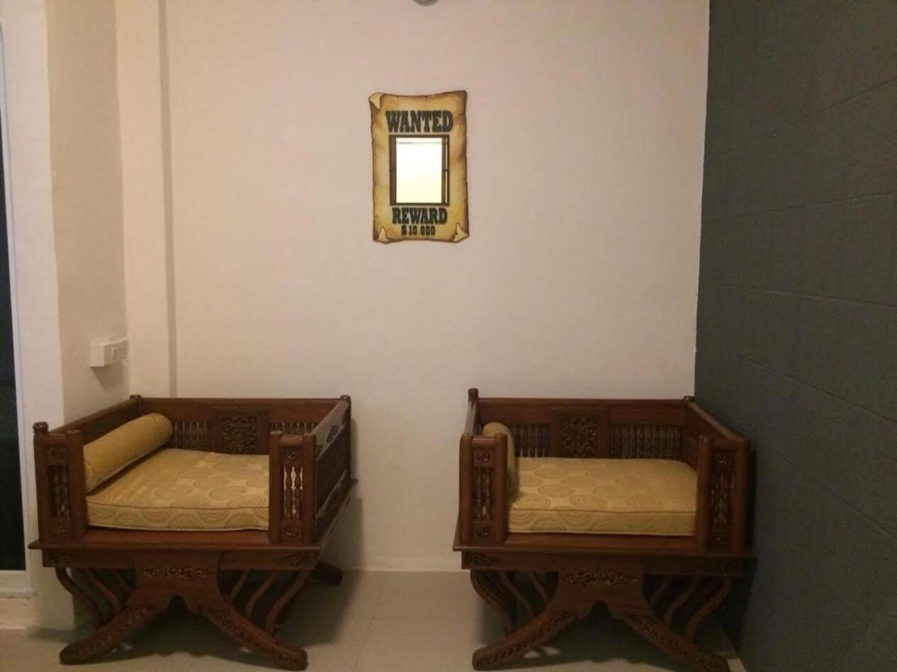 Two wooden beds with headboards and footboards, a wall-mounted 'WANTED' sign, and a plain wall.