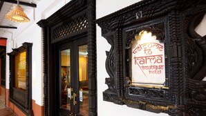 Una puerta negra ornamentada con un letrero que dice 'Welcome to Karma Hotel'.