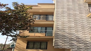 A two-story building with a modern design, featuring a balcony on the upper floor and a window on the lower floor. - Lazimpat Luxury Apartments (Kathmandu)