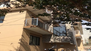 A multi-story residential building with balconies, a parked scooter, and a tree providing shade. - Lazimpat Luxury Apartments (Kathmandu)