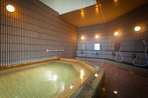 A modern indoor pool area with tiled walls and a central pool.