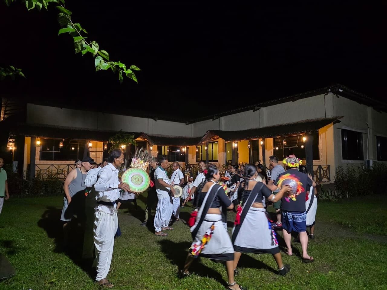 Un groupe de personnes exécutant une danse traditionnelle en plein air, la nuit.