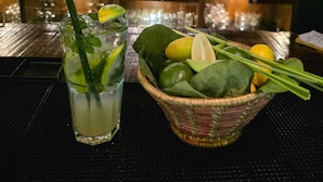 Un bar avec des boissons et des ingrédients frais disposés sur le comptoir.