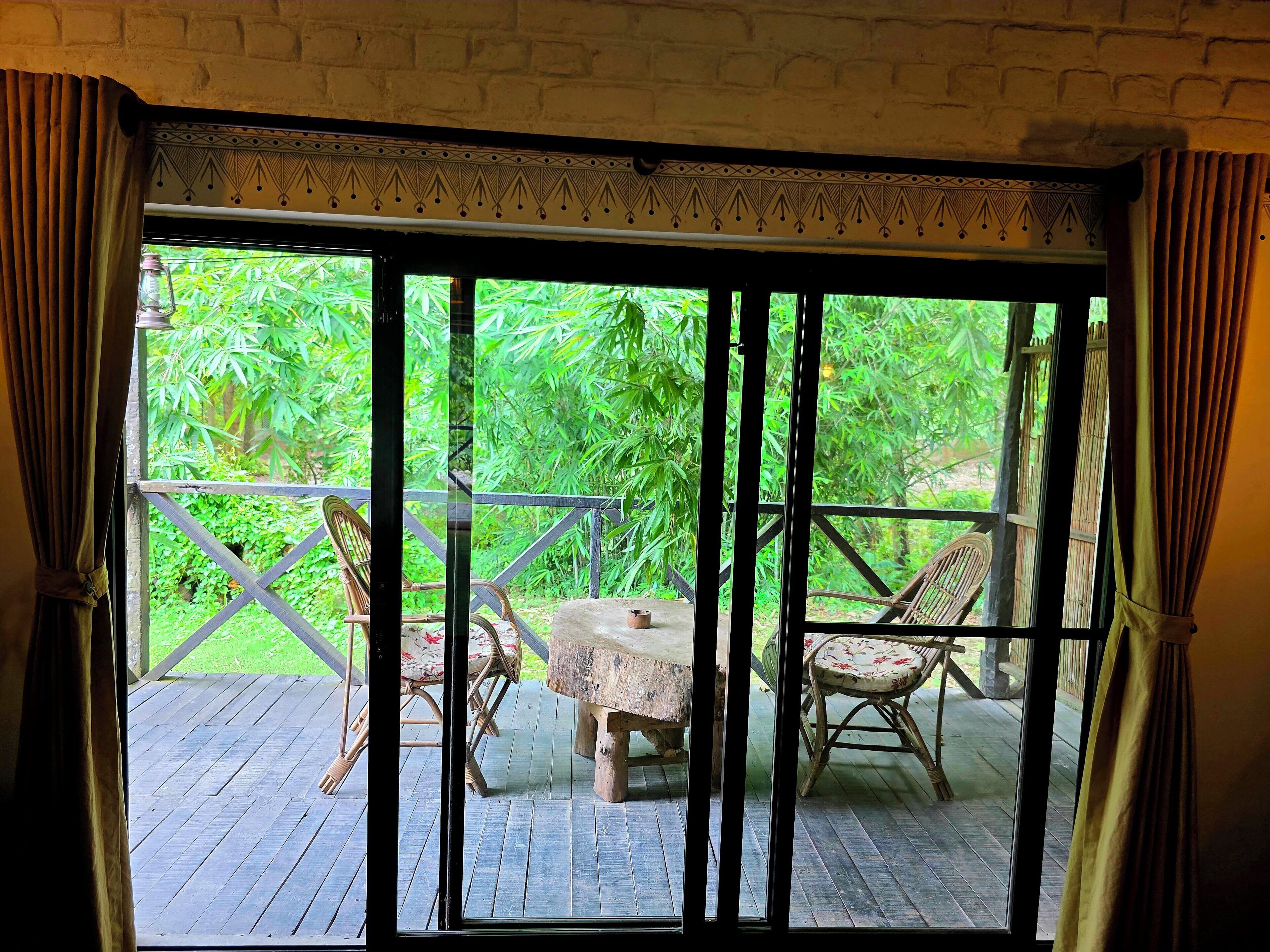 A room with a view of a wooden deck and outdoor furniture.
