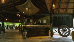 Un intérieur doté d’un plafond en bois rustique, d’un grand banc en bois et d’une roue.