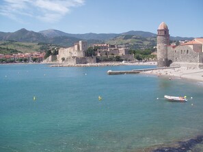 A coastal town with a historic fortification, clear blue waters, and a small boat. - Charming holiday home with typical southern French flair and a beautiful garden (Baixas)
