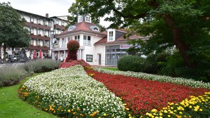 A garden with a statue, a building with a clock, and a sign for 'landscapeworks'. - Vacation Bungalow Bergblüte It is awarded with 4 **** (Bad Harzburg)