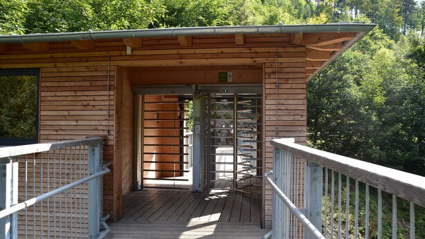A wooden cabin with a metal railing and a door leading to a covered area. - Vacation Bungalow Bergblüte It is awarded with 4 **** (Bad Harzburg)