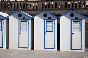 A row of three white portable cabins with blue trim and numbered doors, numbered 318, 319, and 320, under a bridge with decorative arches. - Duplex*** charm and decor, comfortable, equipped, sea 300m, ideal for 4 people (Cabourg)