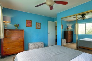 A bedroom with a bed, dresser, and a mirror.