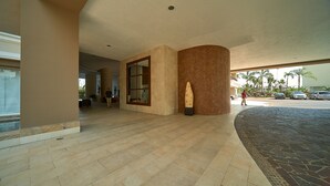 Un hall d’entrée spacieux, doté d’une grande colonne, d’une porte en verre et d’un sol à motifs.
