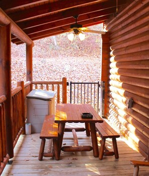 A wooden deck with a picnic table and benches, a small trash can, and a wooden fence. - Amazing Location!!! Hot Tub, Pool Table, Arcade Game (Pigeon Forge)