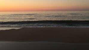 A beach with gentle waves and a clear sky during sunset. -  Just 200 Yards From The Beach. Pet friendly. Fenced back yard. (Saint George Island)