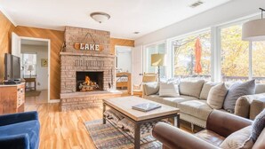 Una sala de estar acogedora con chimenea, sofá, mesa de centro y televisor.