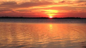 A sunset over a calm body of water with a silhouette of a distant shoreline. - YACHT 33'~FREE KAYAK  (Key Largo)